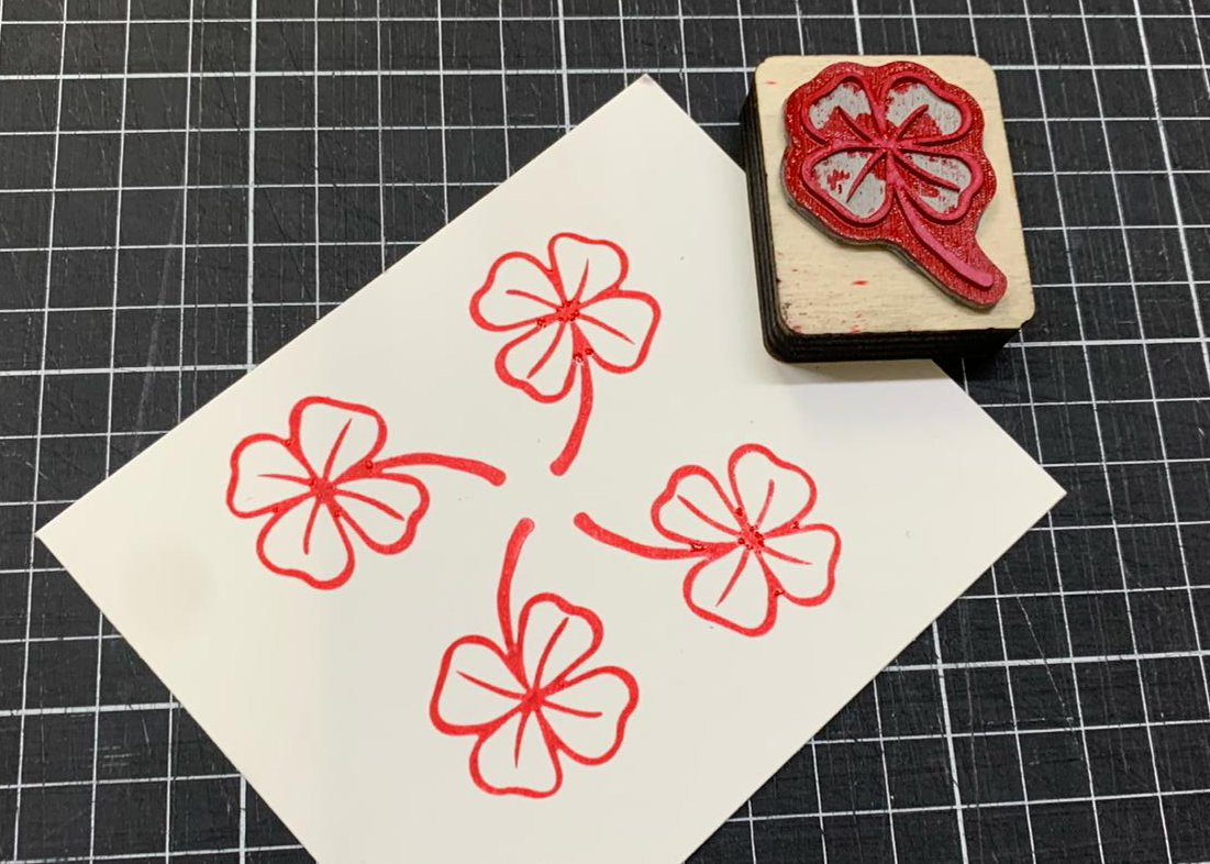 Stempel met een klavertje vier met rode inkt 